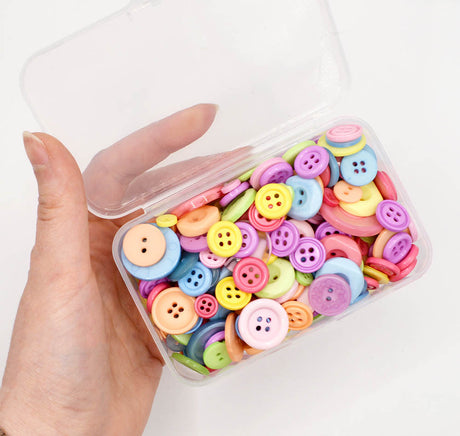 Assortment of sewing buttons in pastel rainbow tones in various sizes and styles. 
