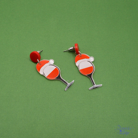 Crafted from lightweight resin, each earring features a whimsical wine glass topped with a playful Santa hat