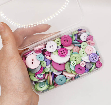 Assortment of purple, green, and pink sew-thru buttons in various sizes and style